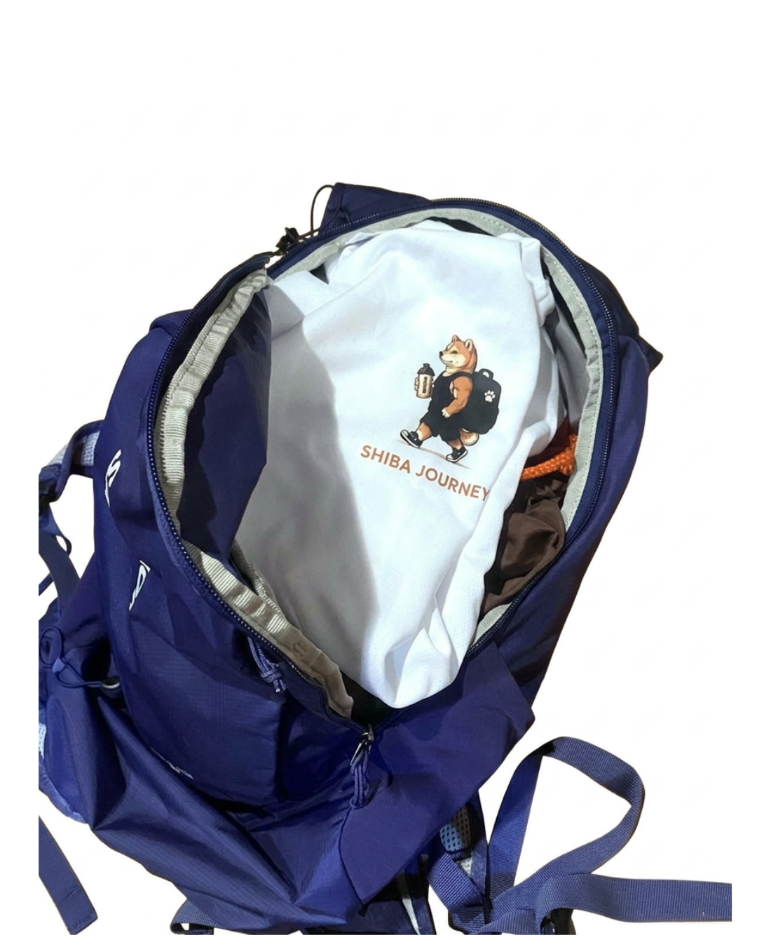 開いたサロモンTRAILBLAZER 20の中に、SHIBA JOURNEYのTシャツが入っている