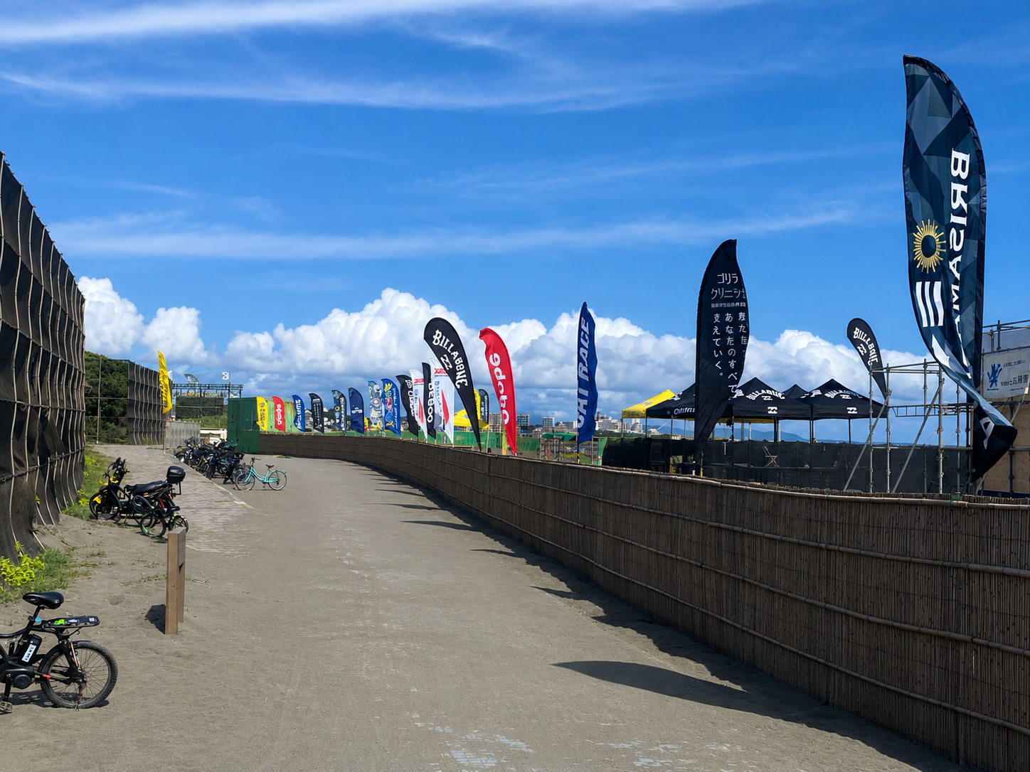 An uncrowded boardwalk lined with beach event flags