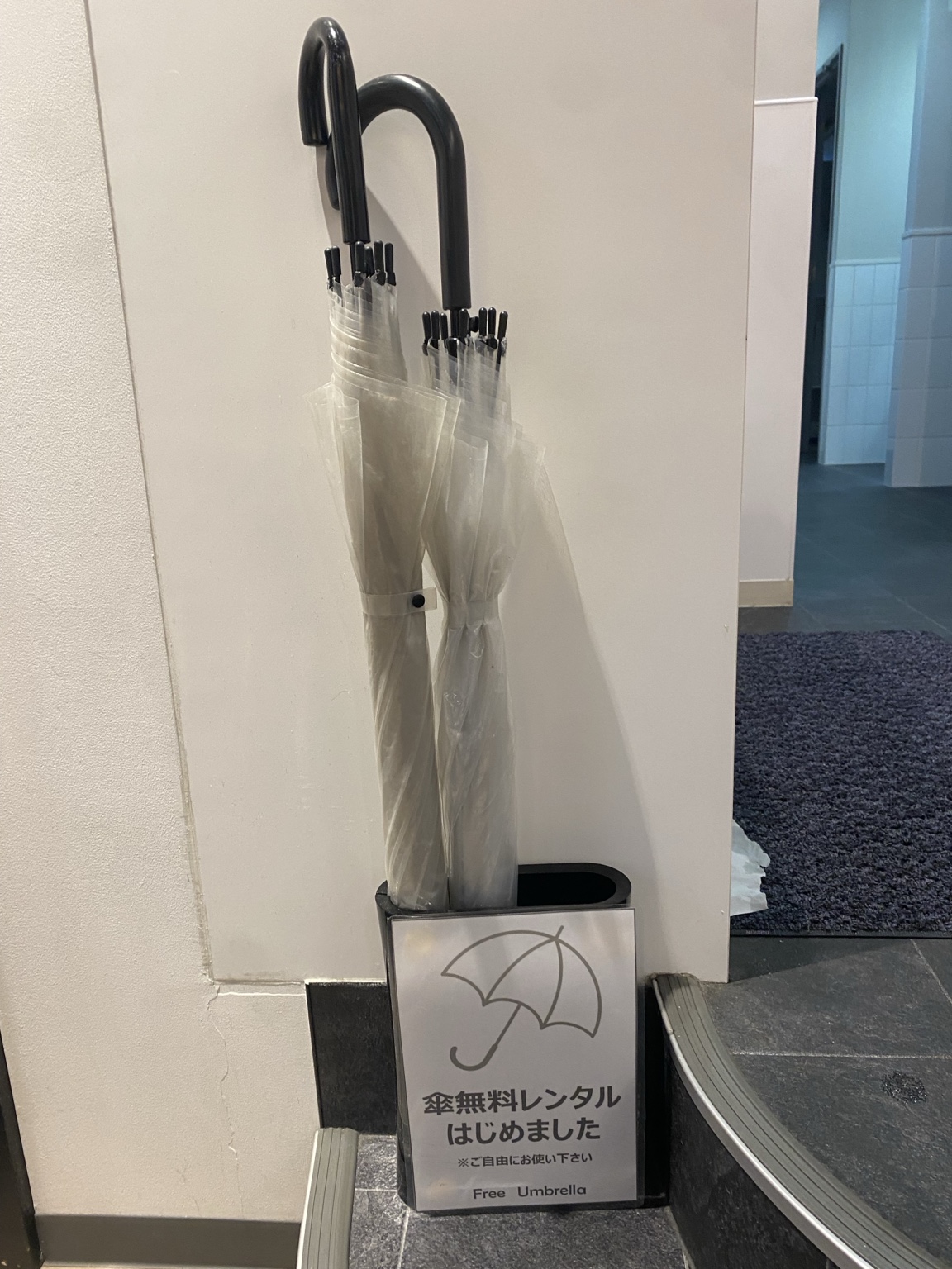 Free rental umbrellas and stand placed at the entrance of Anytime Fitness Koenji