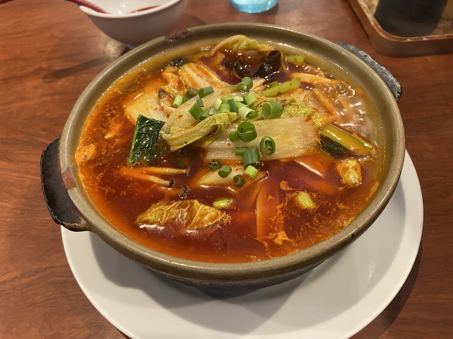 Mala daoxiao noodles at Shoryubo, served in a clay pot with red broth, cabbage and spring onions