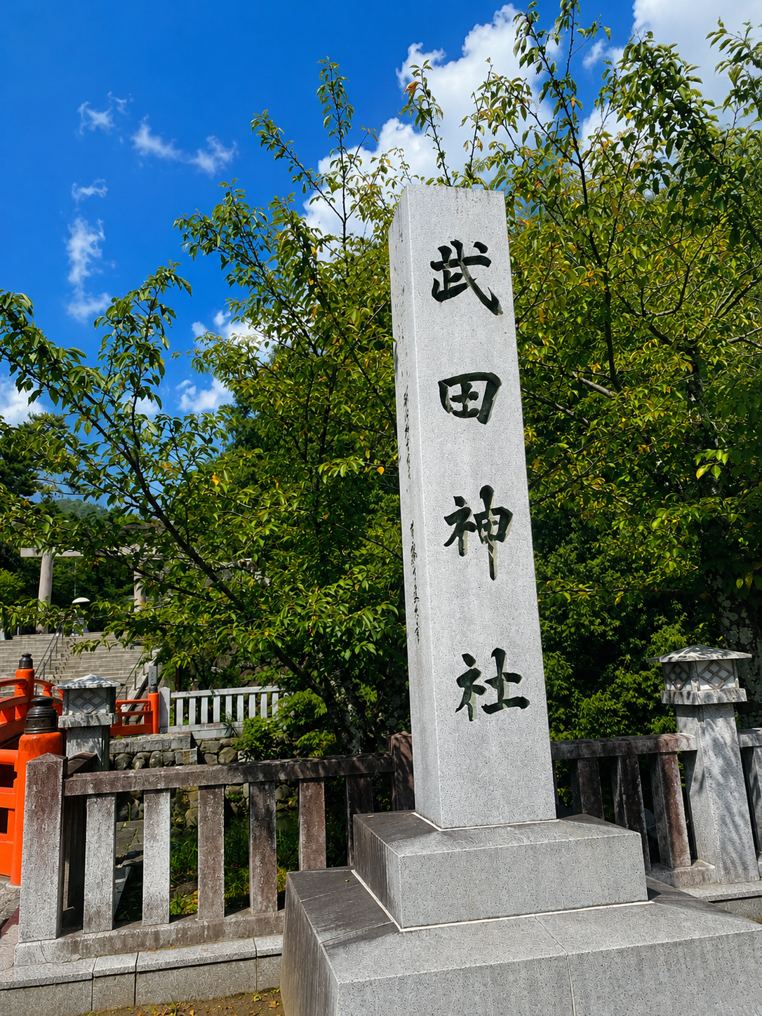 武田神社の社号標。青空を背景に立つ石柱