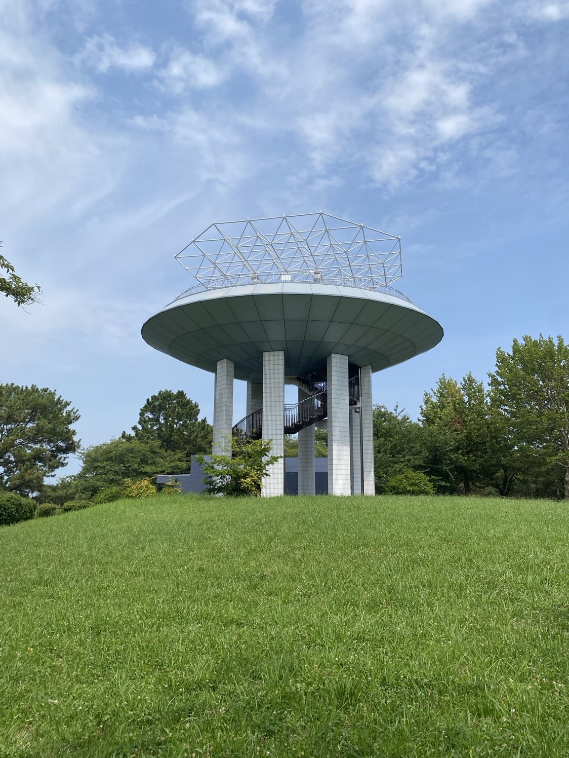 芝生の丘に立つ野島公園展望台。円盤状の屋根と螺旋階段が特徴