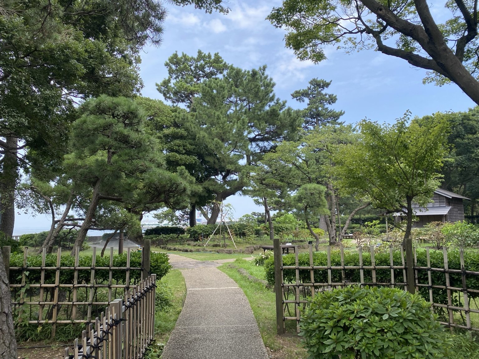 竹垣に挟まれた別邸庭園の小径。手入れされた松が連なる