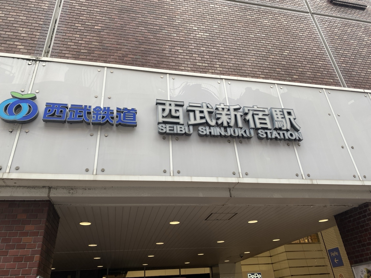 西武新宿駅の駅舎看板と西武鉄道のロゴ