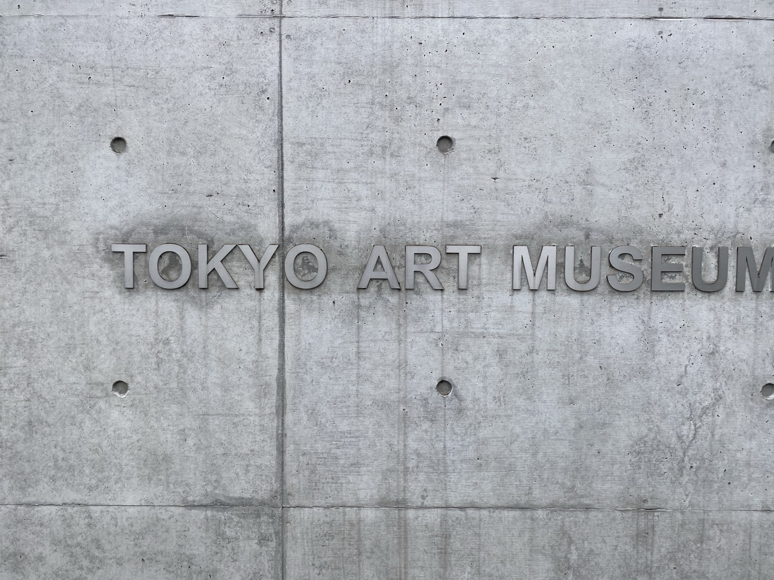 コンクリート壁に掲げられたTOKYO ART MUSEUMの館名