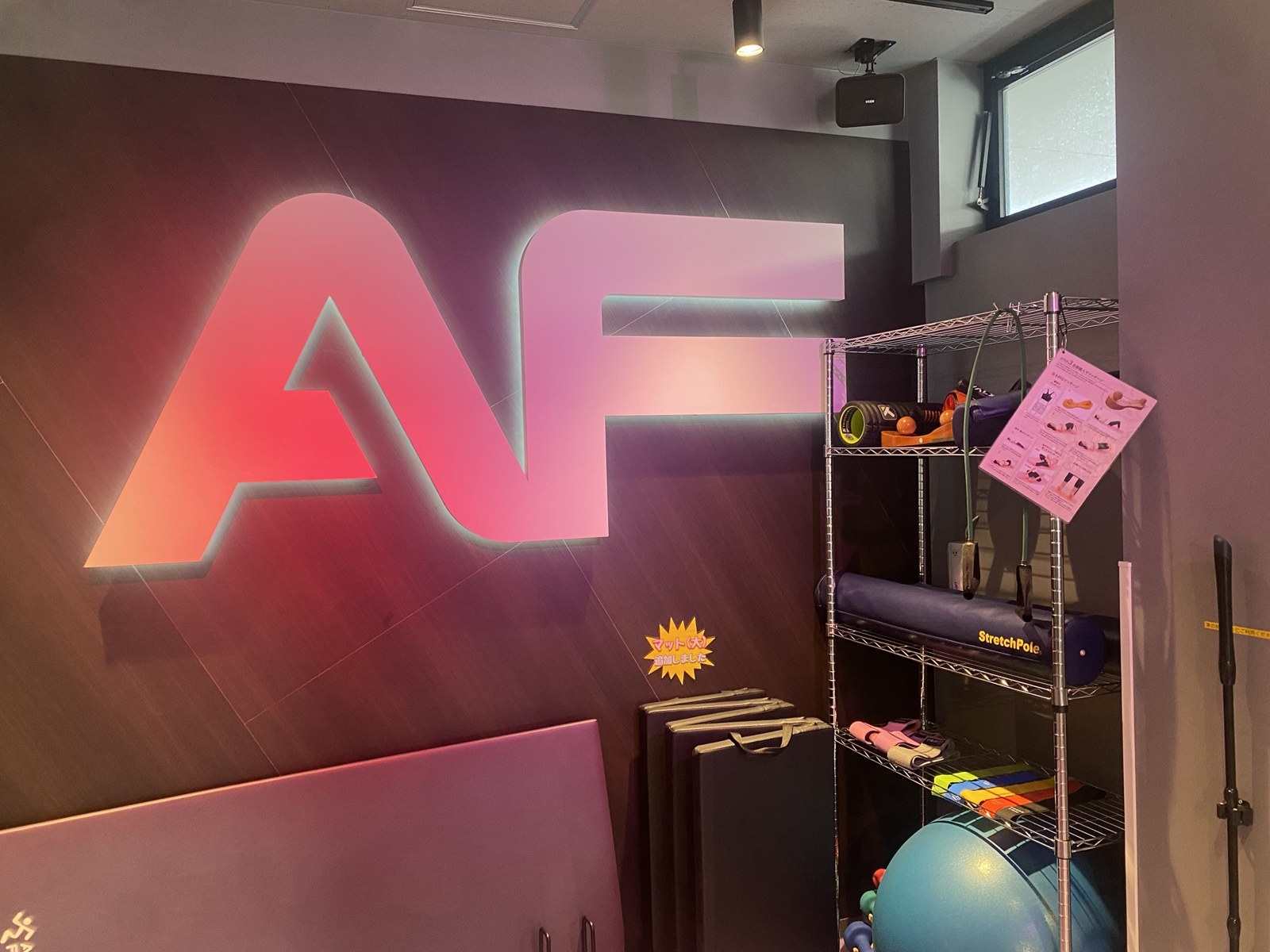 Stretching area at Anytime Fitness Shin-Shibamata with an illuminated AF logo wall
