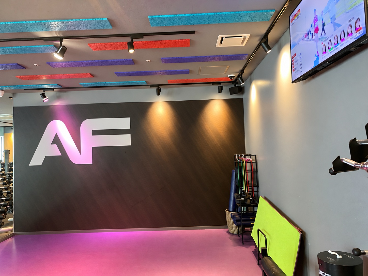 Stretching area with the AF logo wall at Anytime Fitness Akasaka Prudential Tower